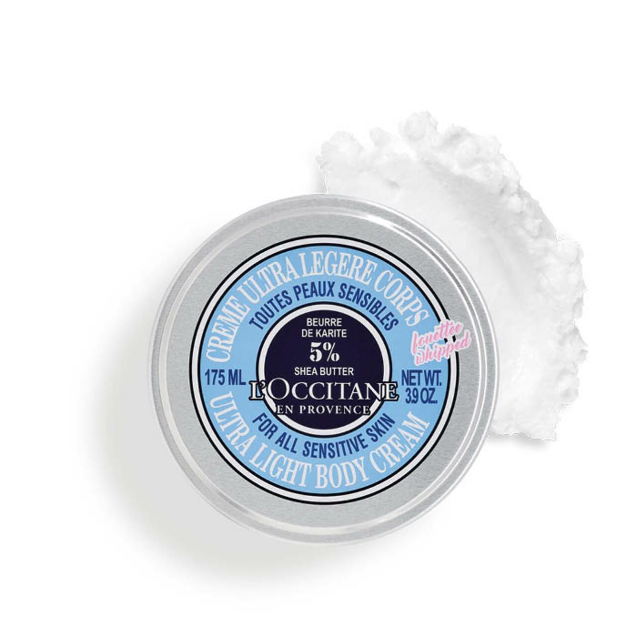 Dose mit blauem Deckel, Aufschrift: Crème Ultra Légère Corps, L'Occitane, 175 ml, 3.9 oz. 5% Shea Butter. Daneben ein Klecks Creme.