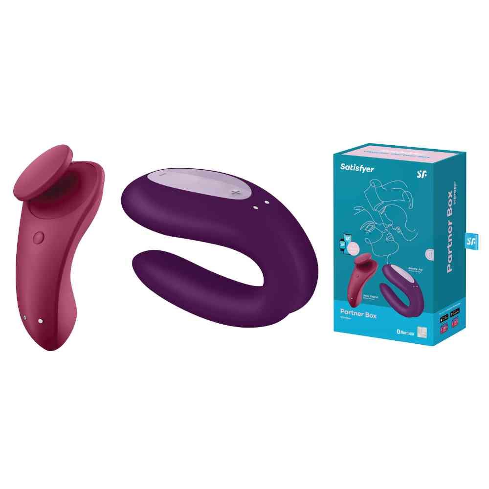 Zwei Geräte und eine Verpackung. Die Verpackung trägt den Markennamen Satisfyer und den Produktnamen Partner Box.