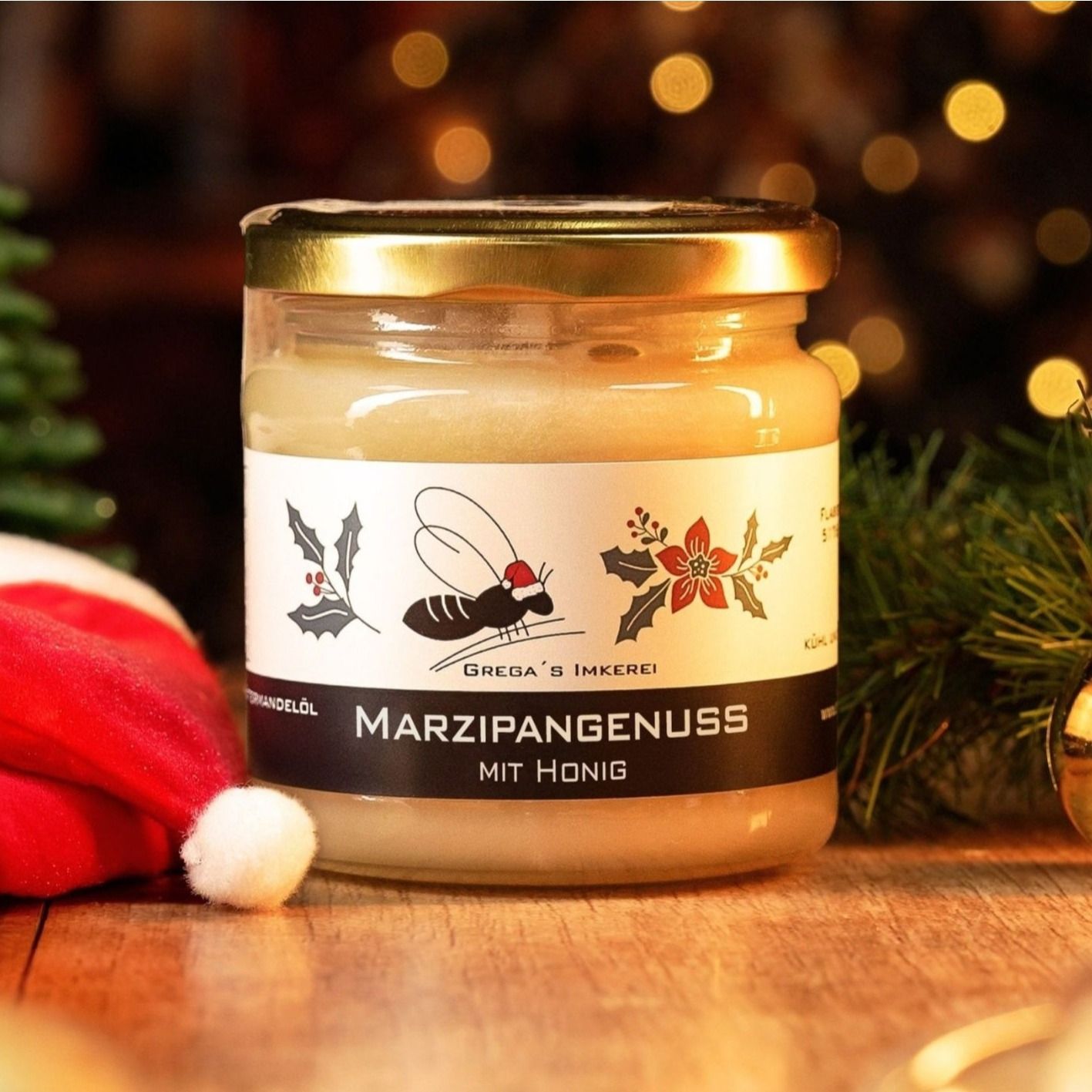 Fünf Gläser Honig-Aufstrich mit verschiedenen Weihnachtsmotiven, umgeben von Tannenzweigen und Dekoration.