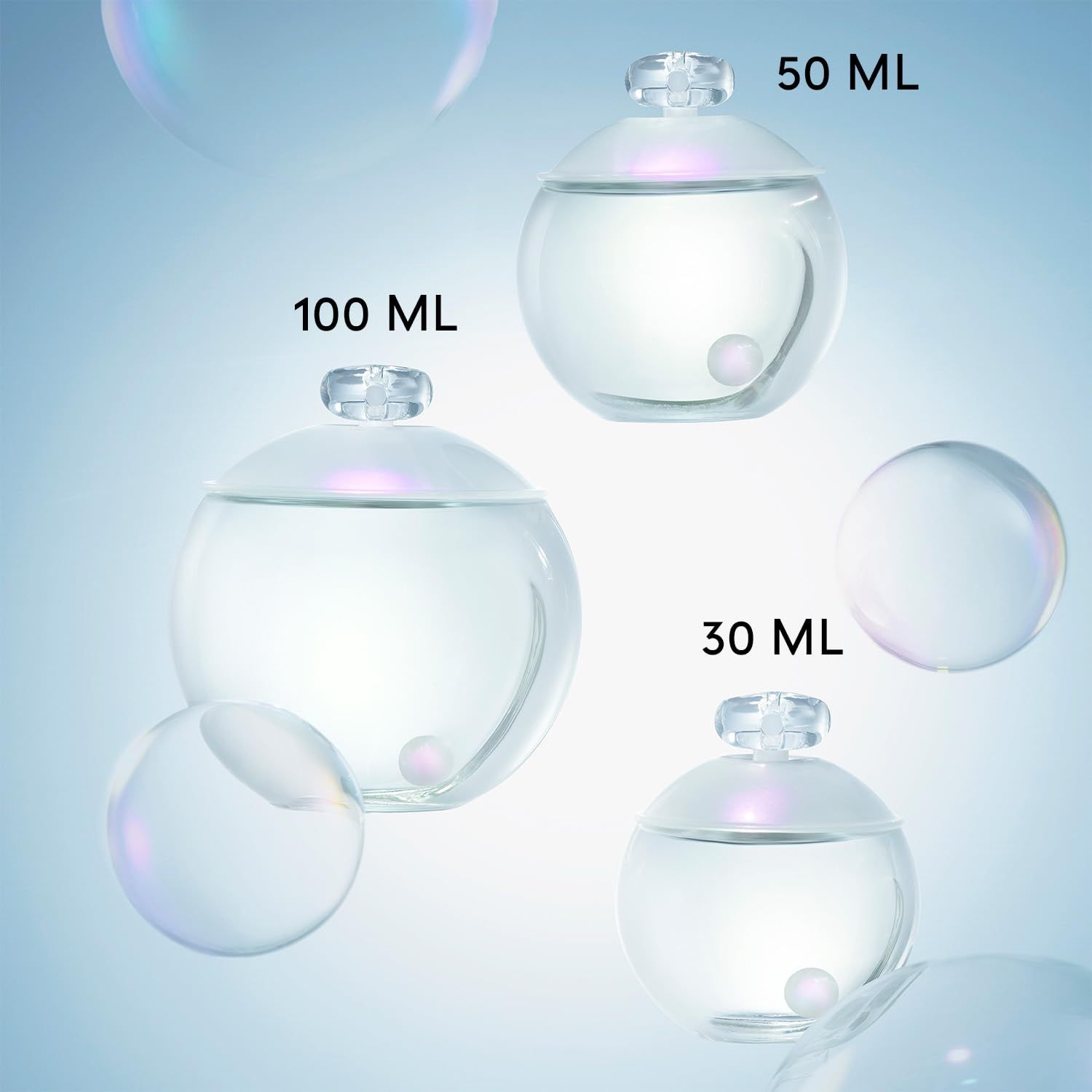 Drei Parfumflakons verschiedener Größen. Runde, transparente Flakons mit Deckel. Beschriftung mit Größenangaben.