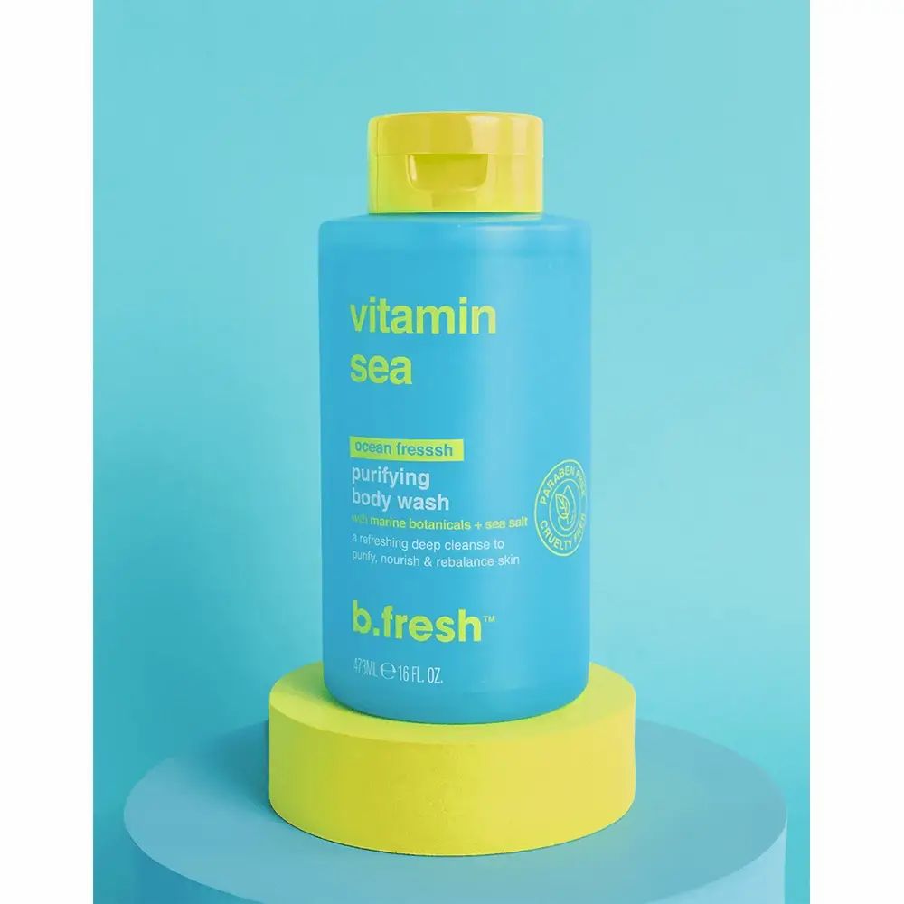 Blau-türkisfarbene Flasche mit gelbem Deckel. Aufschrift: Vitamin Sea, purifying body wash, b.fresh. Flasche steht auf gelbem Podest.