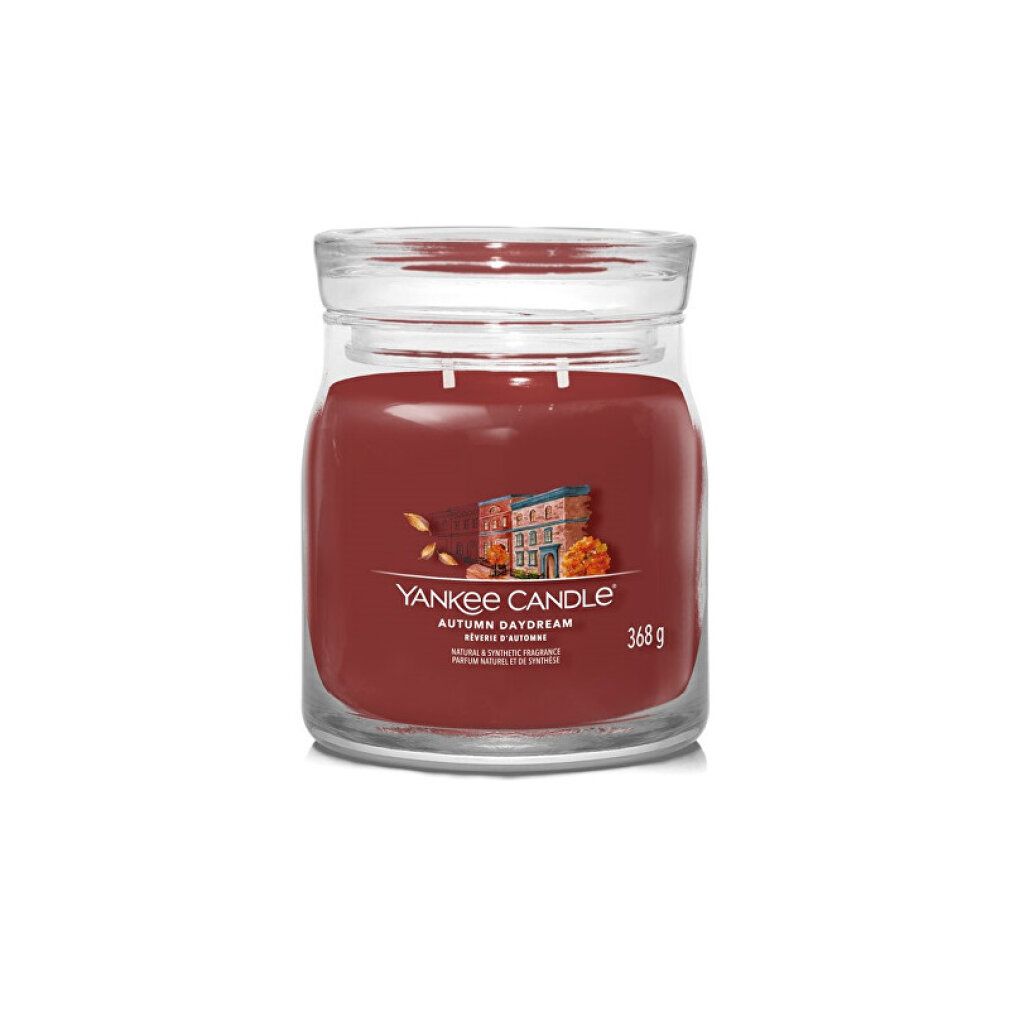 Duftkerze im Glas. Roter Kerzenwachs, klarer Glasbehälter mit Deckel. Aufschrift: Yankee Candle, Autumn Daydream, 368 g.
