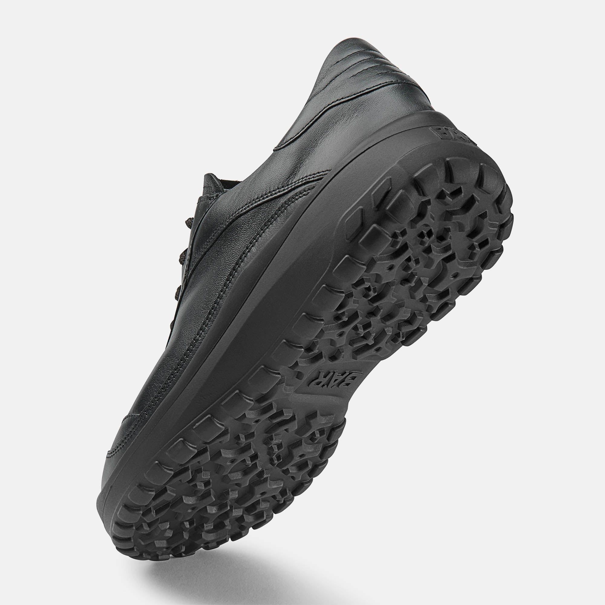 Schwarzer Schnürschuh. Leder-Obermaterial, breite Sohle. Schnürsenkel. Schuh von unten, Sohle mit Profil.