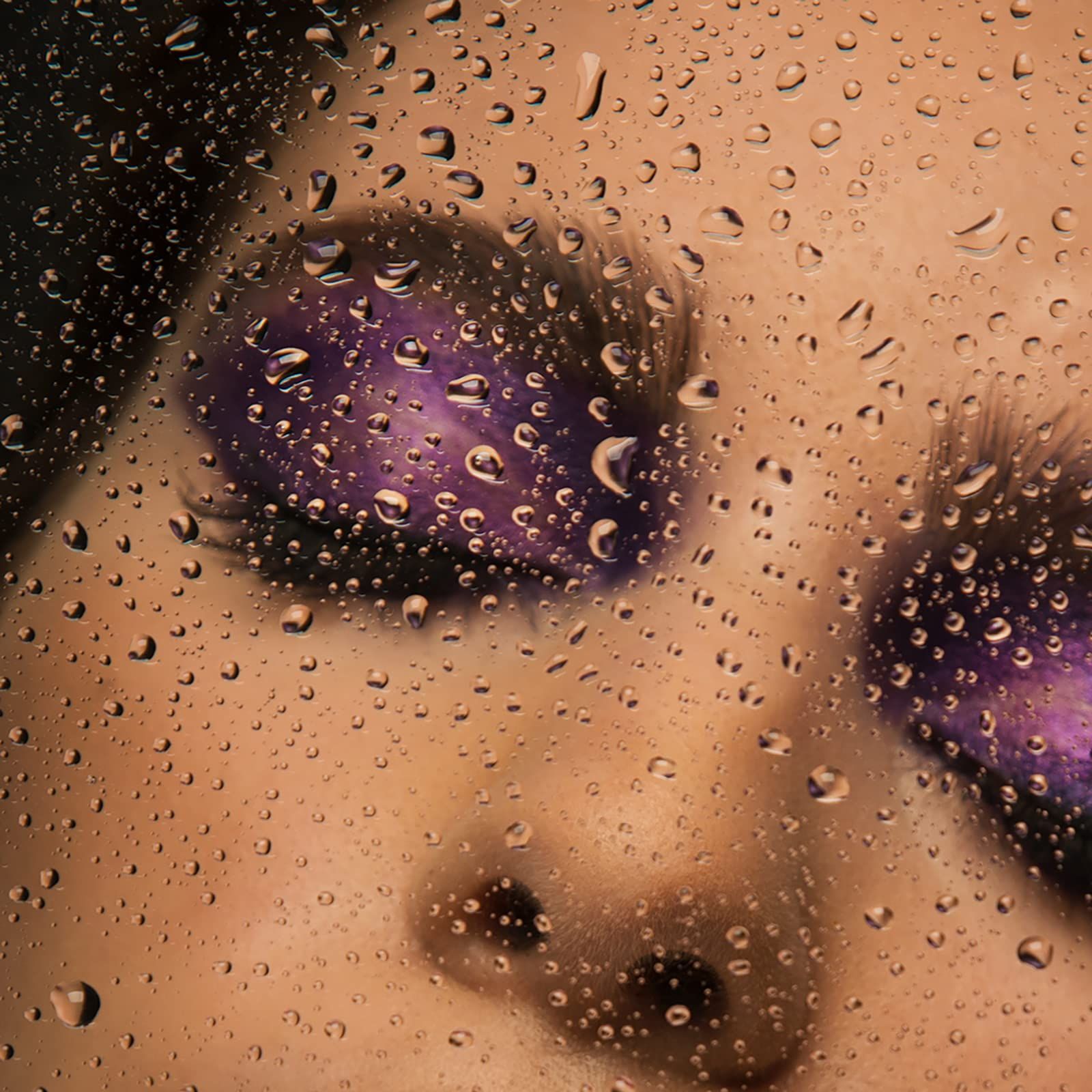Augen mit violettem Lidschatten. Wassertropfen auf einer transparenten Oberfläche.