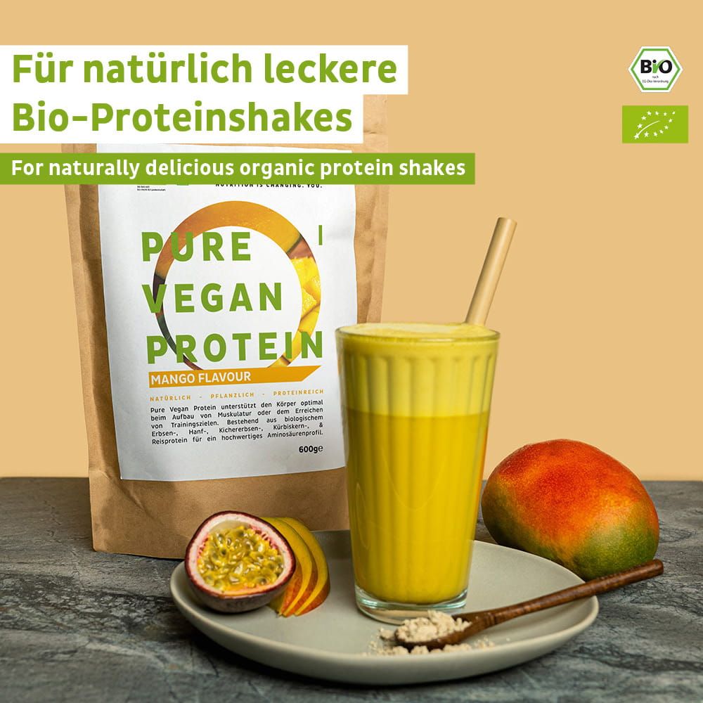 FAIRNATURAL Bio Vegan Protein Pulver Mango Geschmack in einem Glas mit Strohhalm, daneben Mango und Passionsfrucht.