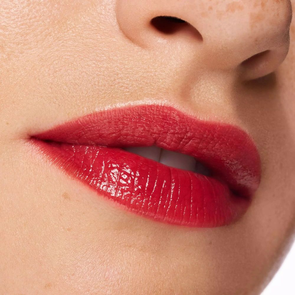 Nahaufnahme von roten, glänzenden Lippen. Haut um den Mund sichtbar.