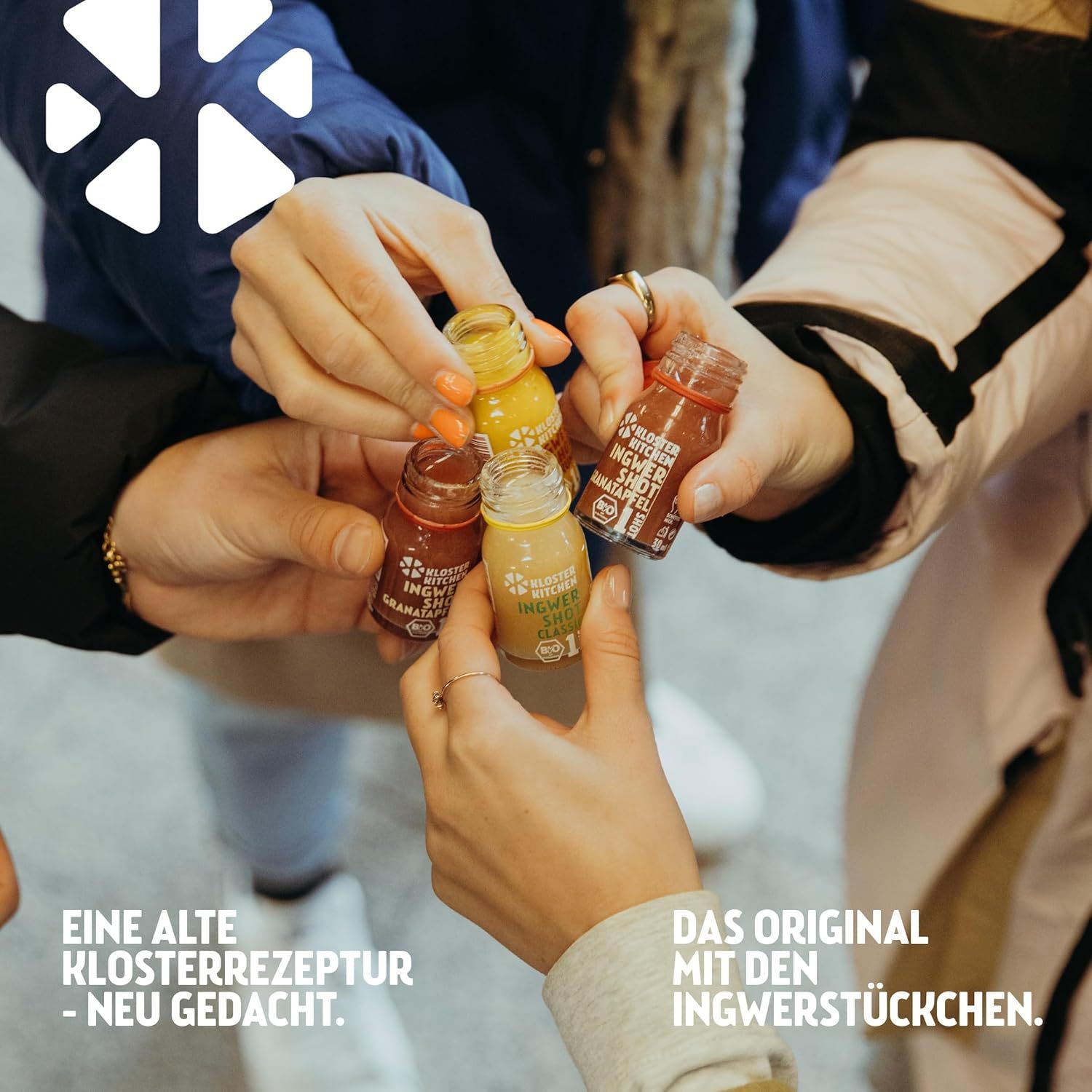 Mehrere Hände halten kleine Flaschen mit farbigen Flüssigkeiten. Text: Eine alte Klosterrezeptur - neu gedacht. Das Original mit Ingwerstückchen.