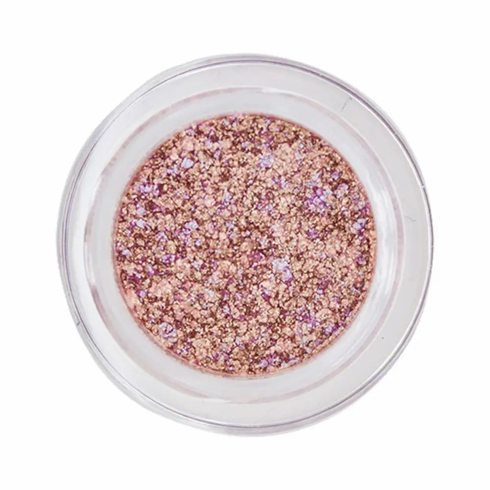 Runder, durchsichtiger Tiegel mit rosa-goldfarbenem Glitzer-Lidschatten. Der Tiegel ist von oben fotografiert.