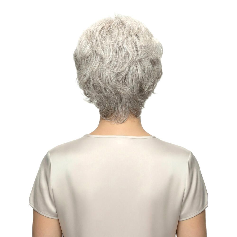 Rückansicht einer Frau mit grauer Perücke. Kurzer, welliger Haarschnitt. Trägt ein helles Oberteil.