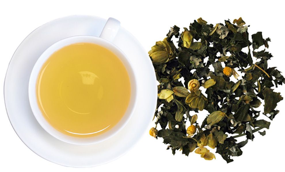 Tasse TeeGschwendner NATURruhe Bio mit Untertasse, daneben lose Kräutermischung. Gelbe Flüssigkeit, getrocknete Kräuter.