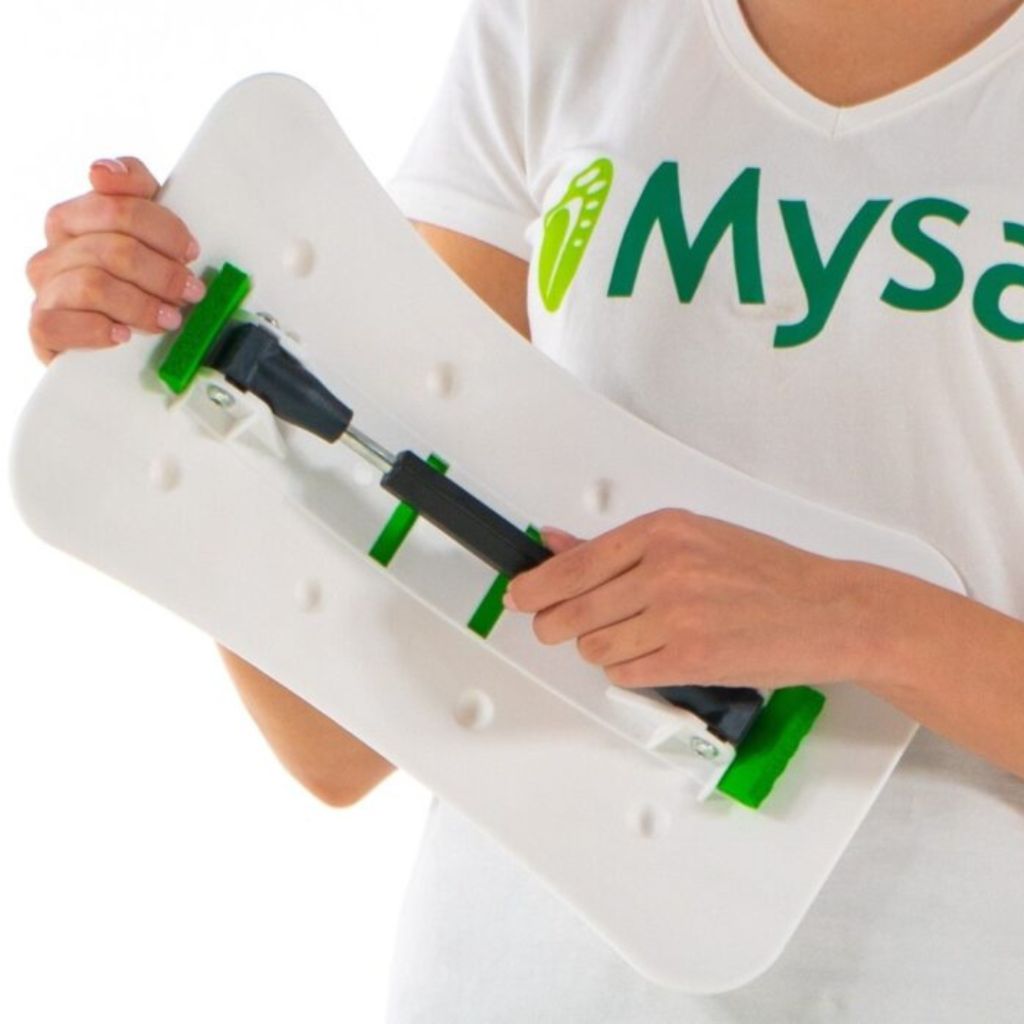 Weißer Rückenstrecker mit grünen Elementen. Person hält das Produkt. Marke Mysa ist sichtbar.