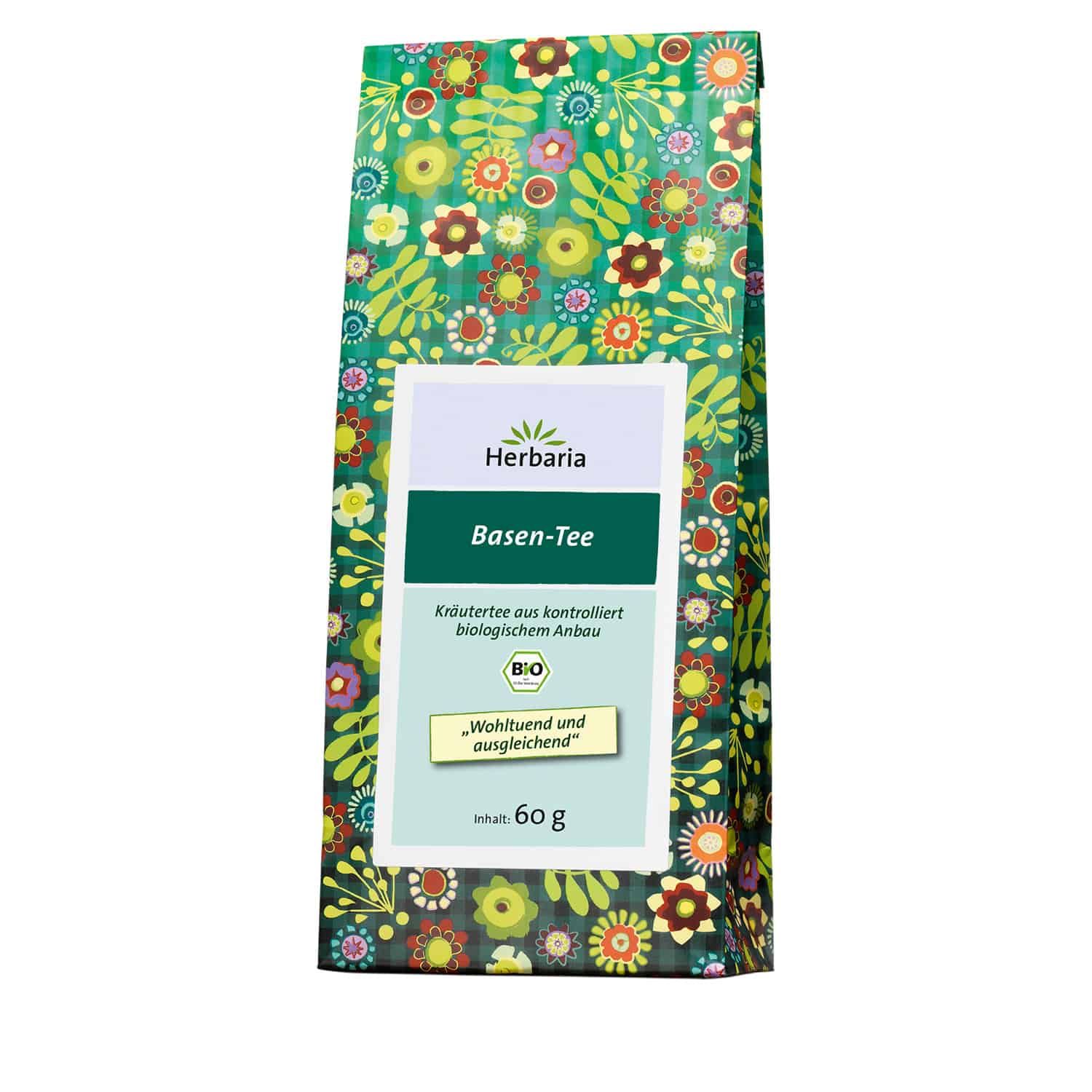 Verpackung von Herbaria Basen-Tee. Grün-blumiges Muster. Weißes Etikett mit Logo, Produktname, Bio-Siegel und Text: Wohltuend und ausgleichend.