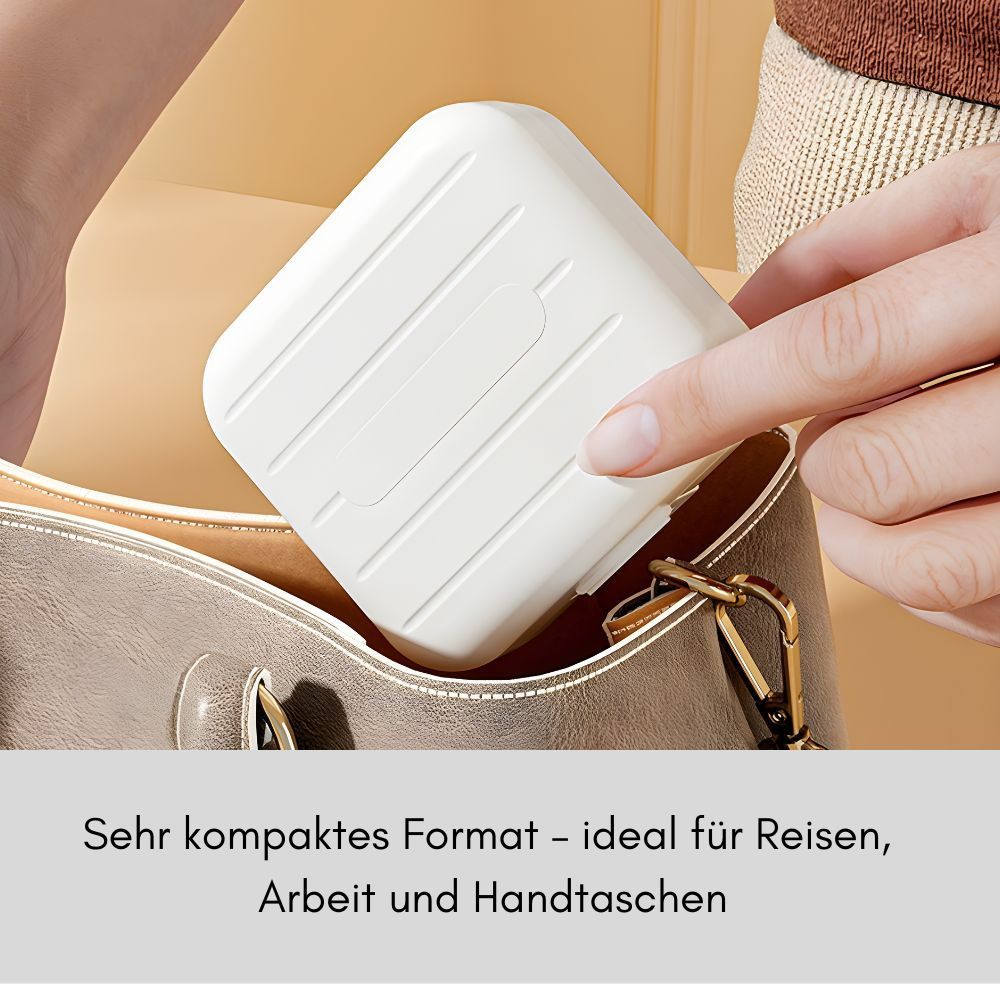 Kompakte, weiße Tablettenbox wird in eine Handtasche gelegt. Der Deckel hat ein geriffeltes Design.