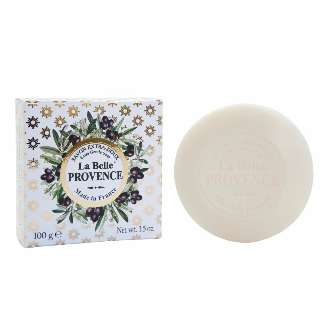 Runde Seife und Verpackung. Verpackung mit floralem Muster und Produktbezeichnung. Seife mit Logo.