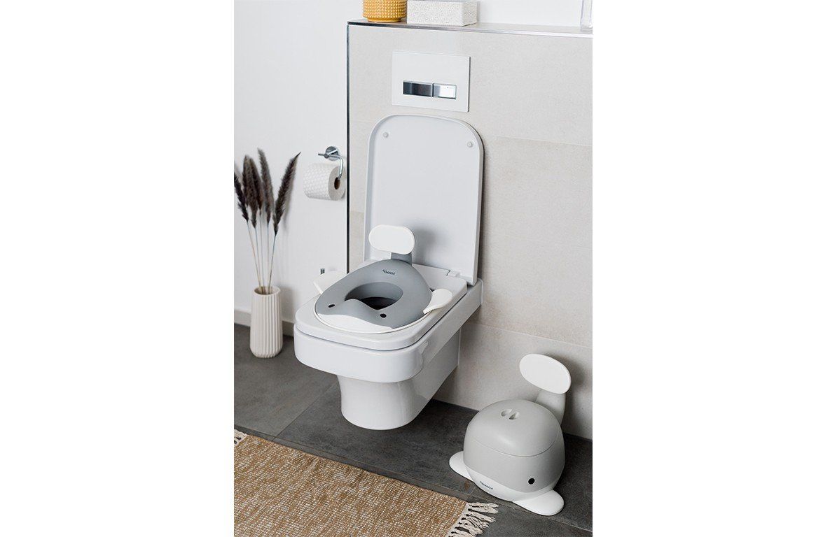 Toilettensitz in Walform auf einer Toilette. Ein weiterer Sitz steht daneben. Badezimmer-Kontext.