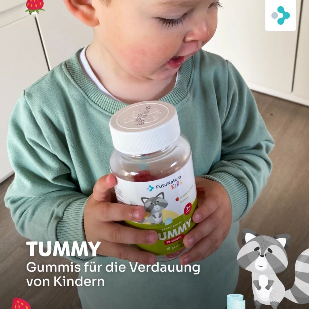 Kind hält Flasche FutuNatura Tummy Kindergummies. Etikett mit Waschbär, Erdbeere und Text: 3+ Jahre, Probiotisch, 30 Gummies.