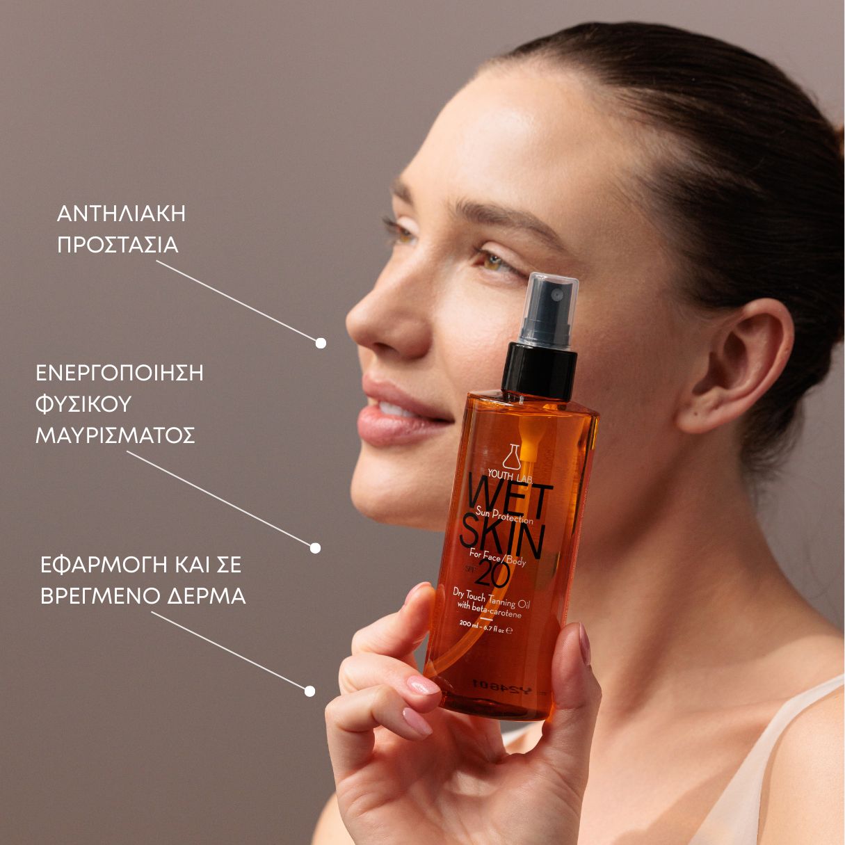 Bräunungsöl-Flasche mit Sprühkopf. Aufschrift: Wet Skin SPF 20. Frau im Hintergrund.