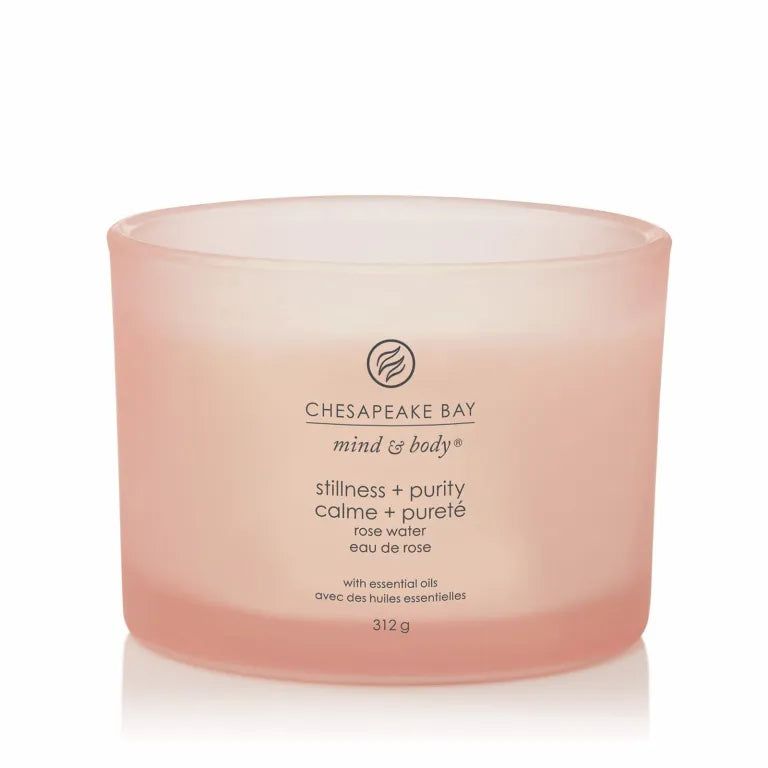 Rosafarbene Kerze mit Aufschrift 'Chesapeake Bay'. Text: 'stillness + purity', 'rose water'. 3 Dochte. 312g.