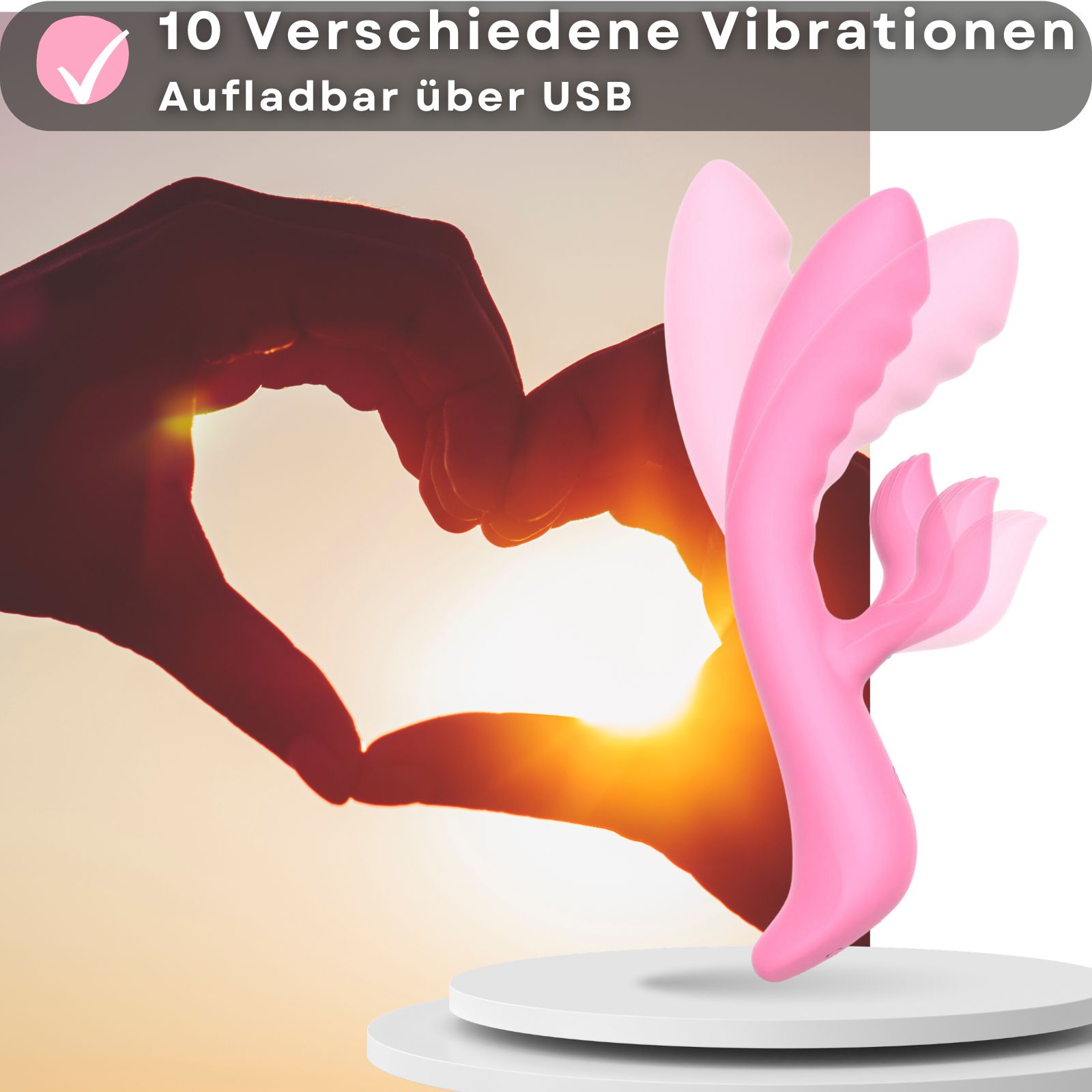 Rosa Vibrator mit Hasenohren. 10 Vibrationen. Aufladbar über USB. Hände formen Herz. Auf weißer Oberfläche.