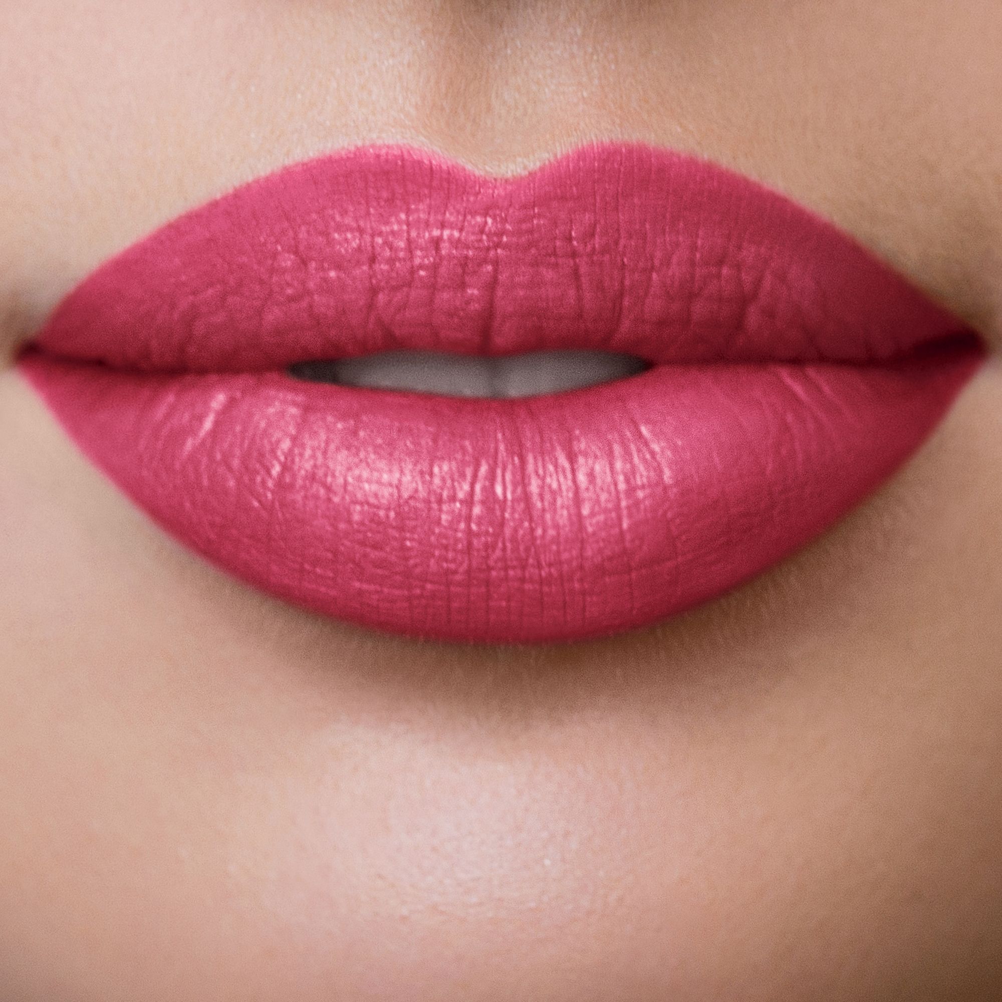 Nahaufnahme von Lippen, bedeckt mit "Magenta Dream" Lippenstift. Glatte, matte Oberfläche.