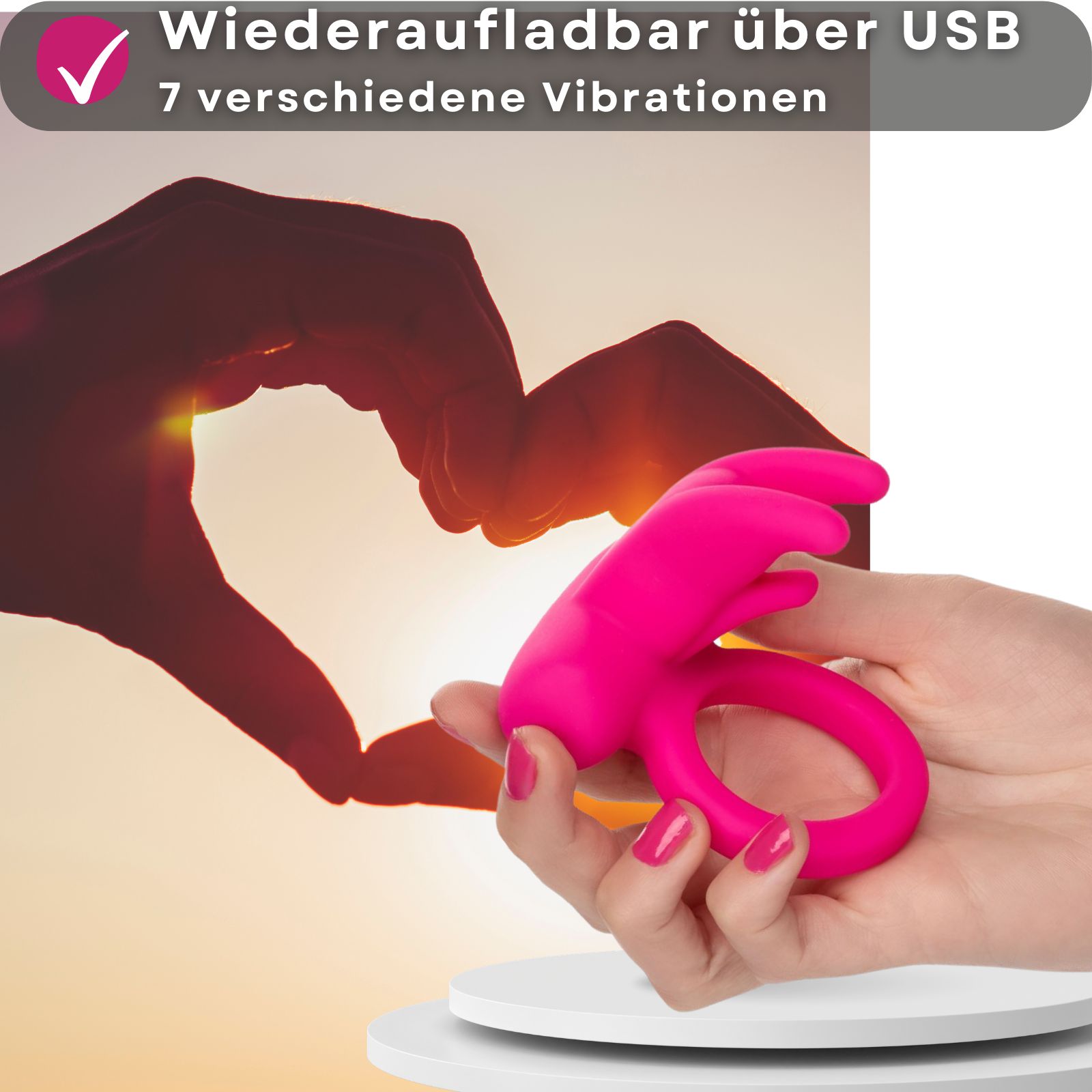 Pinkfarbener Penisring mit Hasenohren, Silikon. Auf weißem Podest, Hintergrund: Hand, Herz.