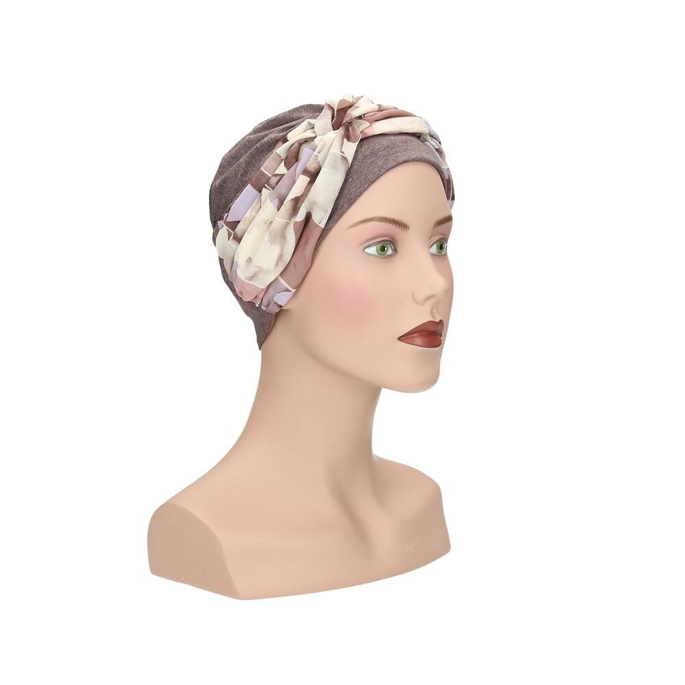 Turban Nora, floral Muster. Grauer Stoff, floraler Überwurf. Auf einer Büste präsentiert.