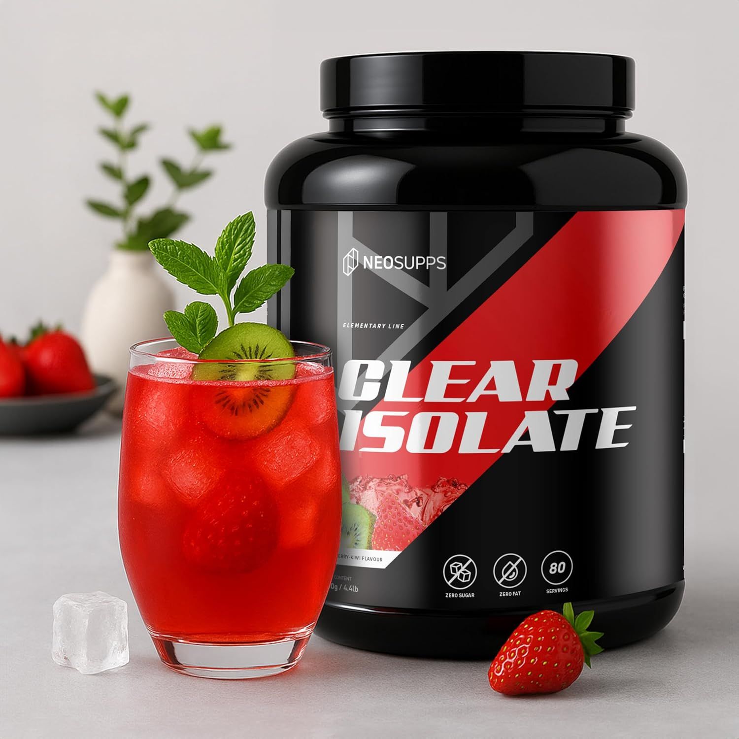 Schwarze Dose Clear Isolate neben Glas mit Getränk. Aufschrift: Clear Isolate. Glas mit Erdbeere und Kiwi. Erdbeere daneben.