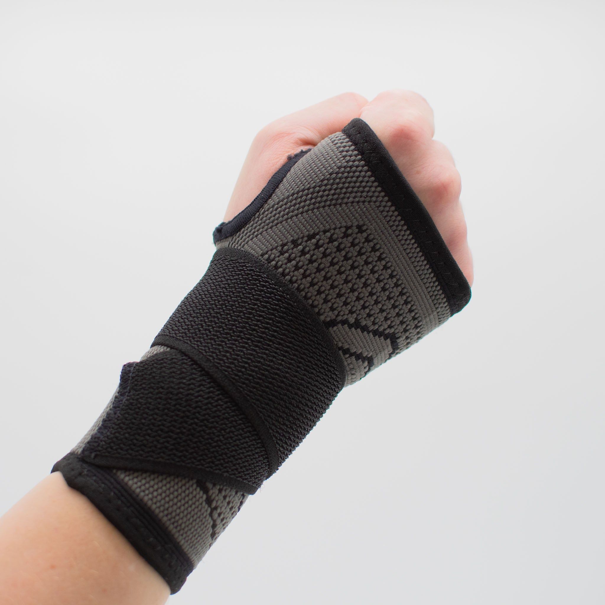 Handgelenkbandage. Grau-schwarzes Textil. Hand in Faust, Bandage mit Klettverschluss.