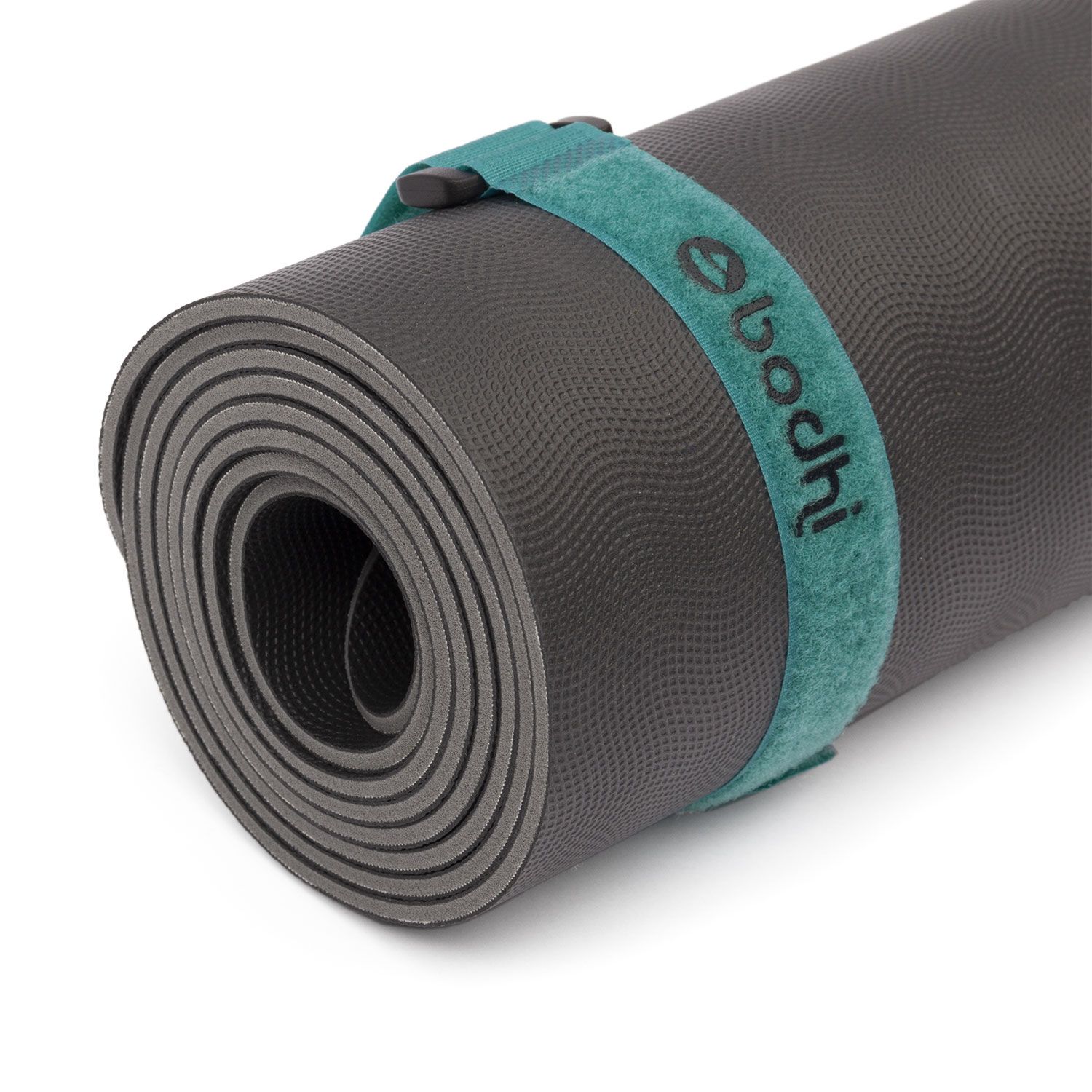 Gerollte Yogamatte mit grünem Klettband. Band mit Logo 'bodhi'.
