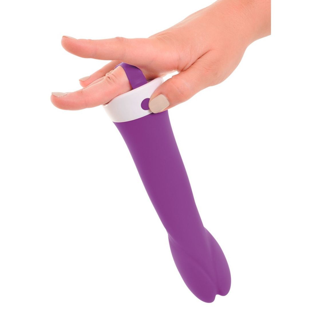 Lila Vibrator, gehalten von einer Hand. Weißer Ring am oberen Ende. Auf weißem Hintergrund.
