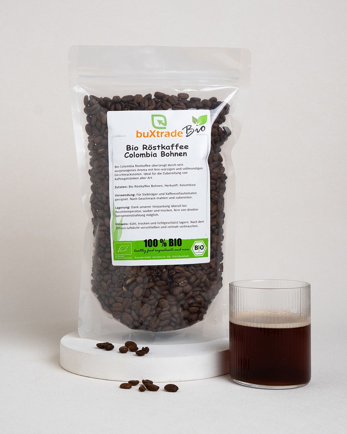 Verpackung mit Bio-Röstkaffee Colombia Bohnen neben einem Glas Kaffee.