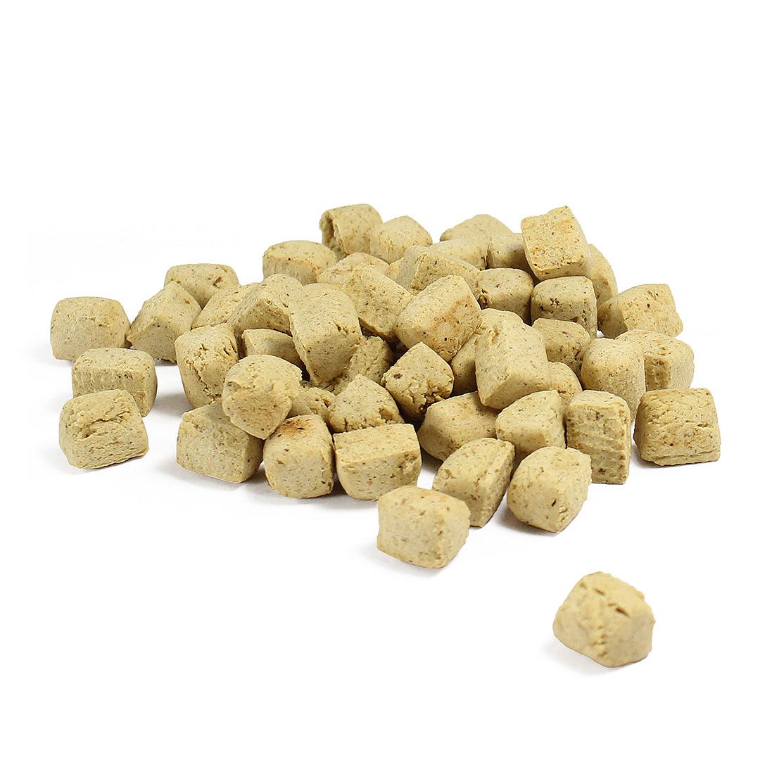 Haufen quadratischer, hellbrauner Hundekekse. Einzelne Kekse sind sichtbar. Auf weißem Hintergrund.