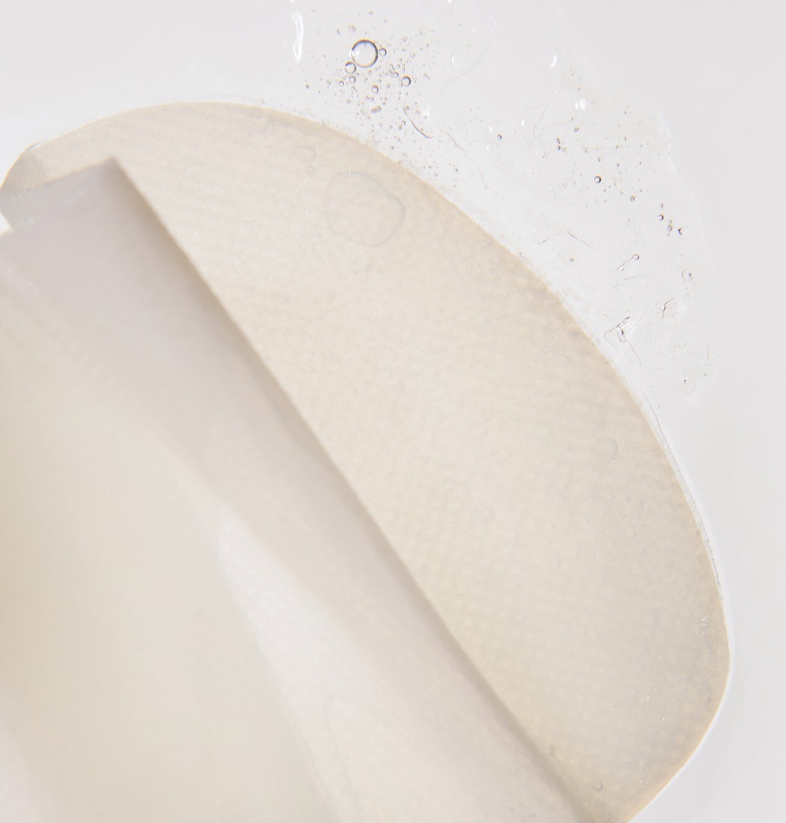 Nahaufnahme einer Dekolleté-Maske. Weiße, feuchte Maske mit Flüssigkeit. Geformt für den Hals- und Brustbereich.