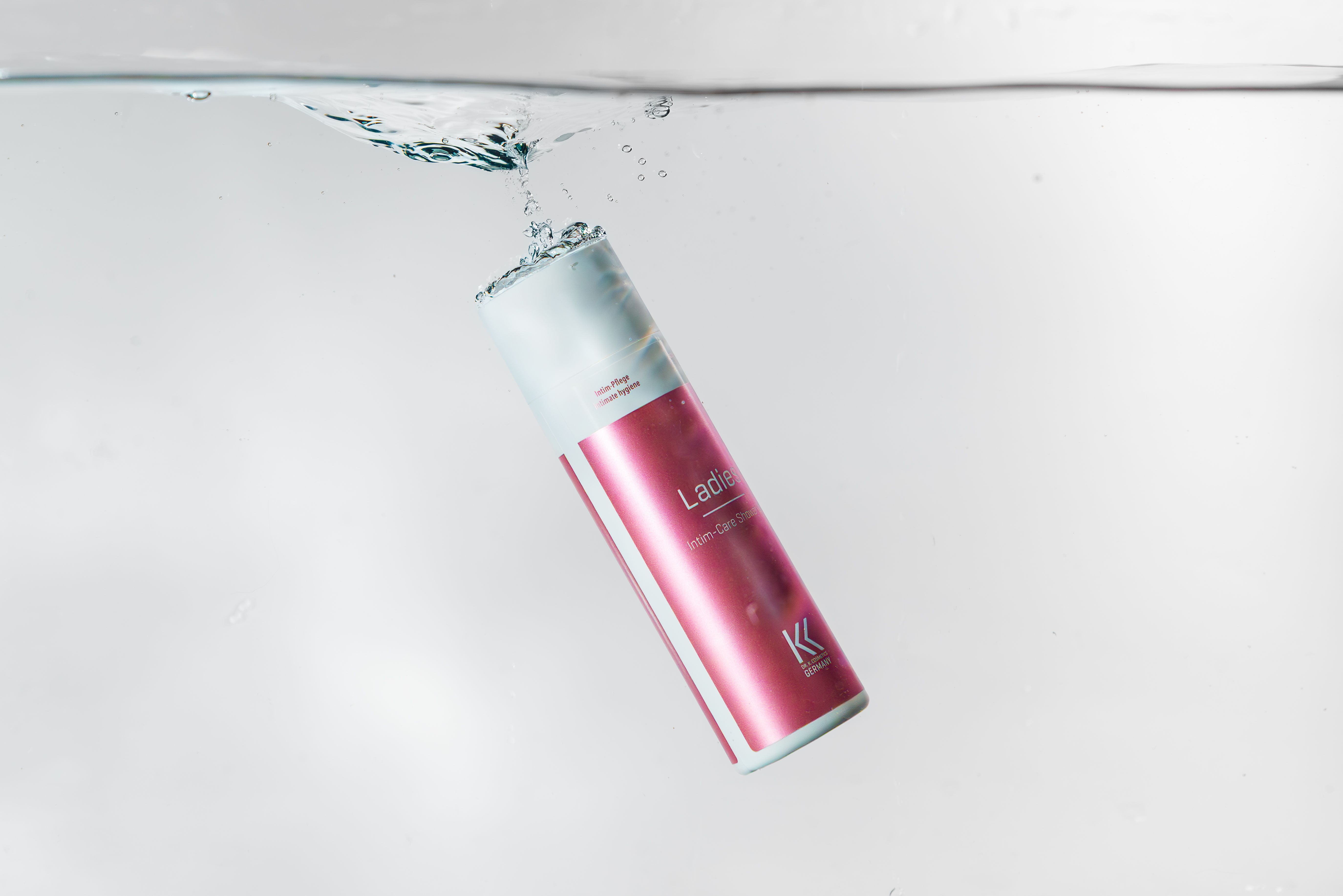 Spender im Wasser. Aufschrift "Ladies Intim-Care Cream" und Logo. Produkt für Intimpflege.