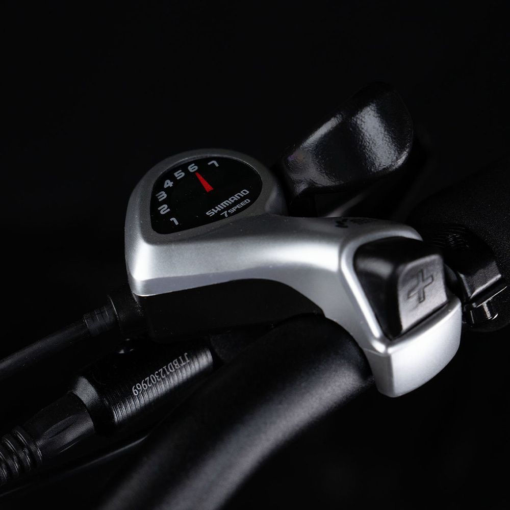 Nahaufnahme des Schalthebels. Shimano 7-Gang-Anzeige. Schwarzer Hintergrund.