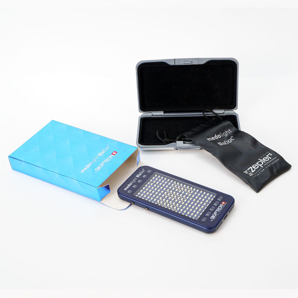 medolight BluDoc-Gerät, blaue Box, Etui und Beutel. Gerät rechteckig, mit LEDs. Box und Etui blau, Beutel schwarz.