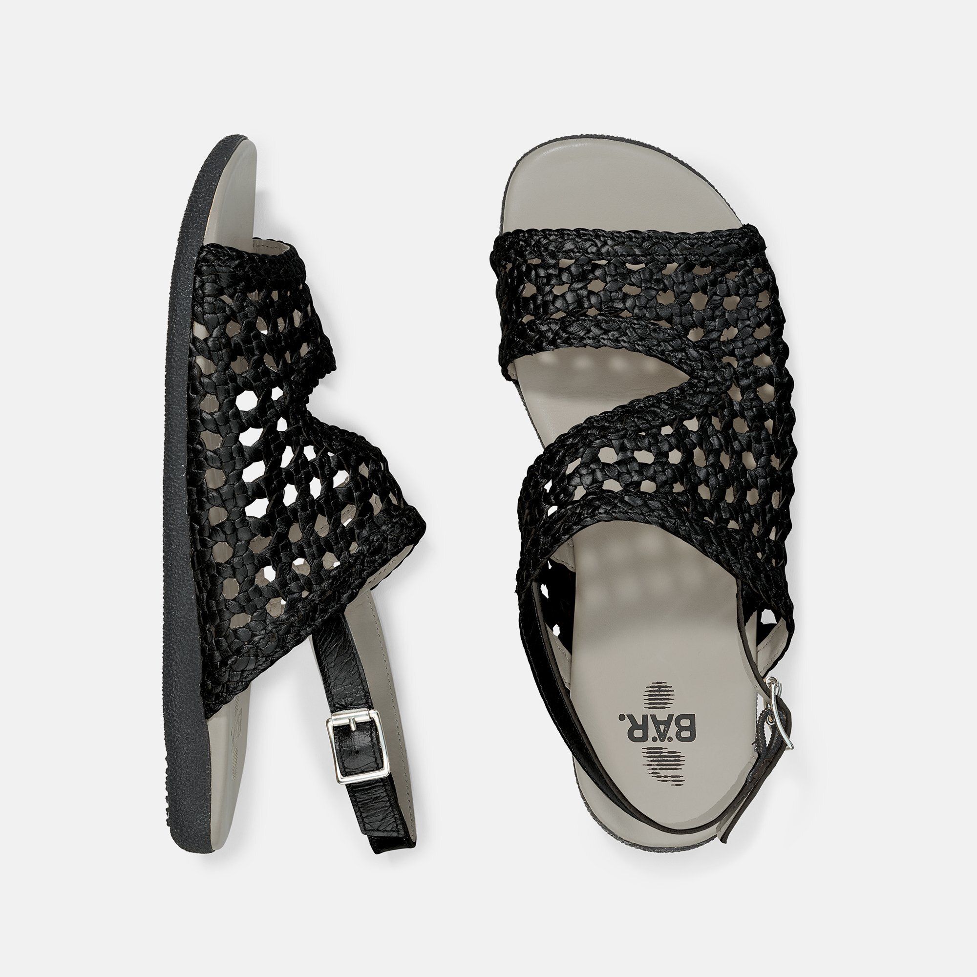 Draufsicht auf zwei schwarze Sandalen. Geflochtenes Obermaterial. Riemen mit Schnalle. Graue Sohle. BÄR-Logo.