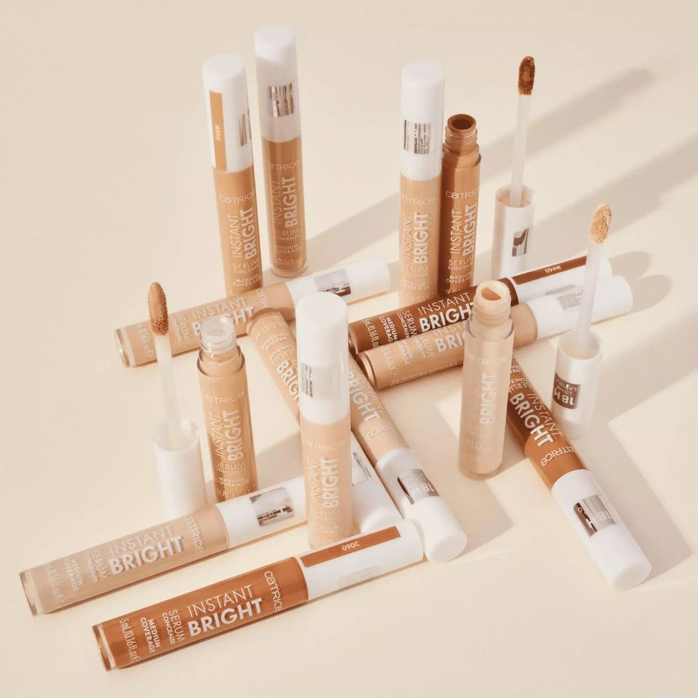Mehrere Catrice Instant Bright Serum Concealer. Geöffnete und geschlossene Tuben, Applikatoren.
