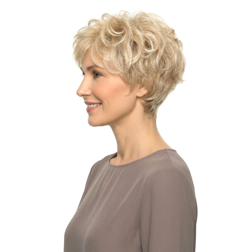 Blond gelockte Perücke. Seitenansicht einer lächelnden Frau mit braunem Oberteil.