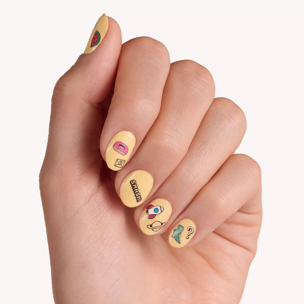 Hand mit gelb lackierten Nägeln. Auf den Nägeln sind Nagelsticker mit verschiedenen Motiven angebracht.