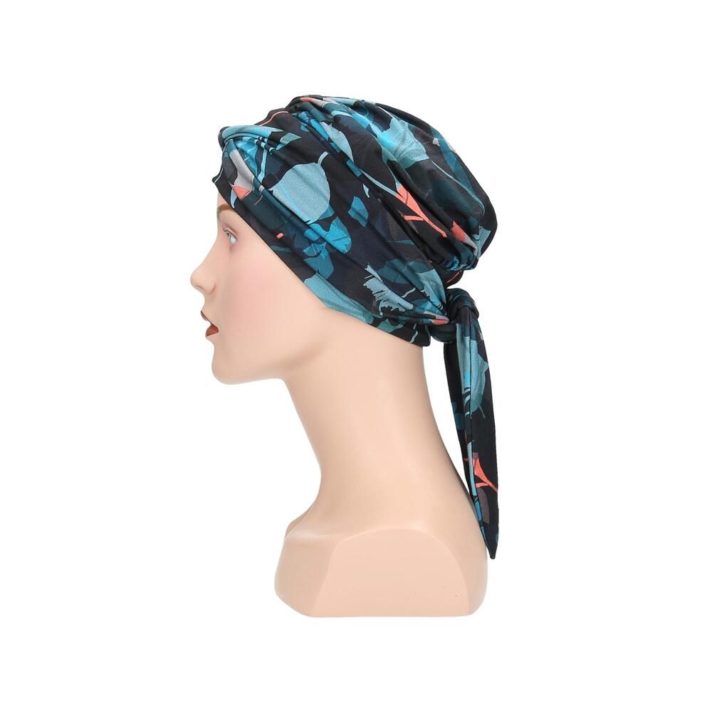 Turban Letti, floral bedruckt, auf einer Büste. Farben: Schwarz, Türkis, Rosa. Stoff mit Falten. Seitenansicht.