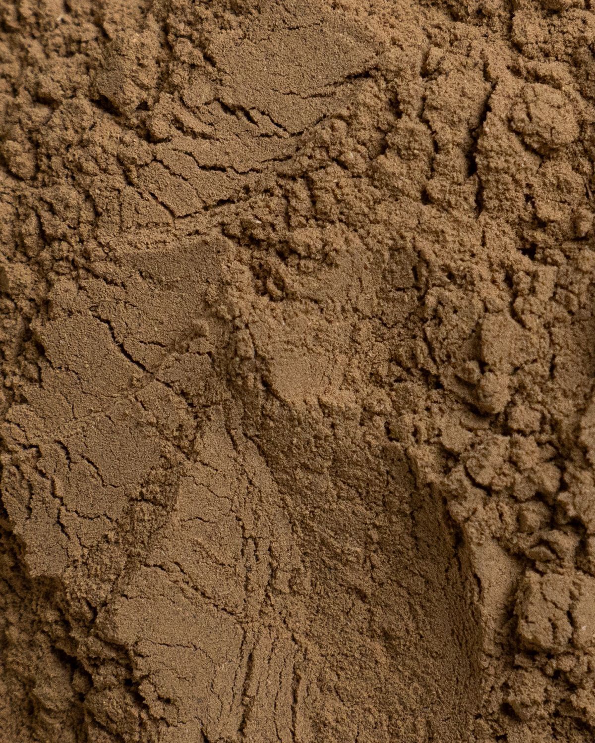 Nahaufnahme von braunem Pulver. Die Oberfläche ist uneben und weist Risse auf.