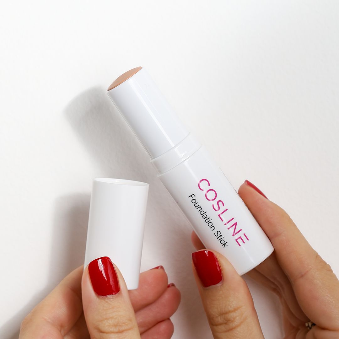 Hände halten einen weißen Foundation Stick und dessen Kappe. Aufschrift: Cosline Foundation Stick.