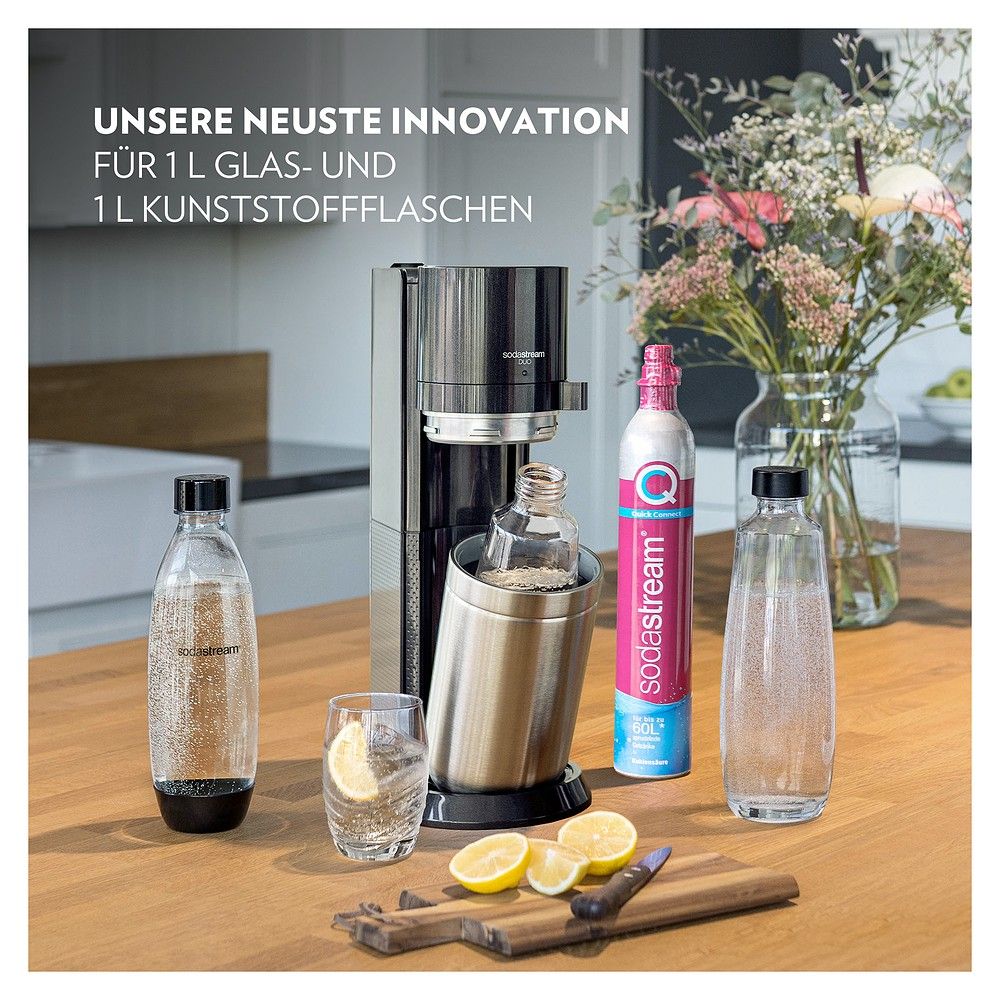 Sodastream Soda Duo mit Flaschen, Glas, Zitronen und Blumenstrauß.