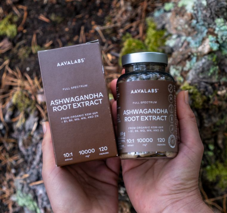 Hände halten Aavalabs Ashwagandha Flasche und Karton im Freien.