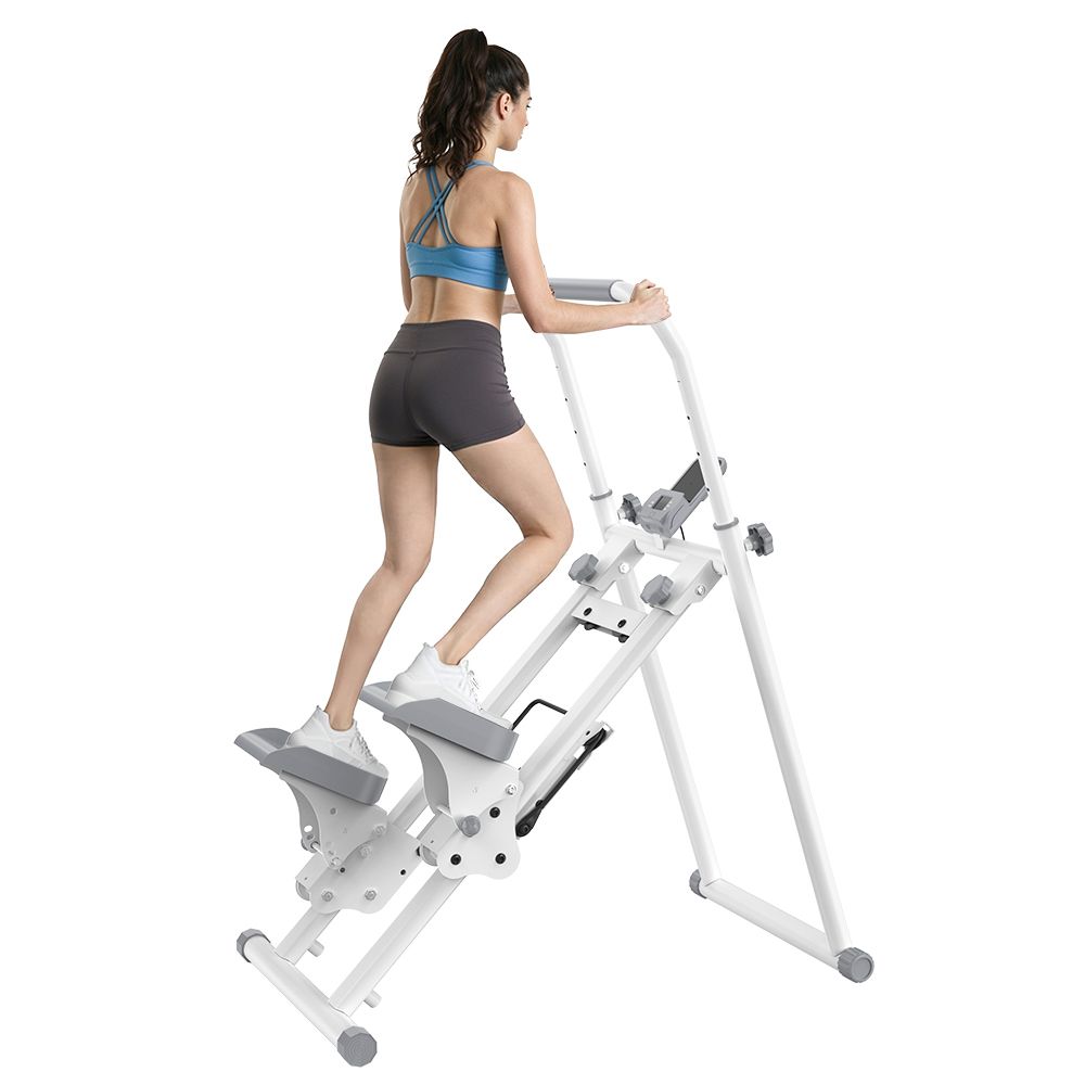 Eine Frau trainiert auf einem weißen Stepper mit Lenker und Pedalen. Der Stepper hat ein Display.
