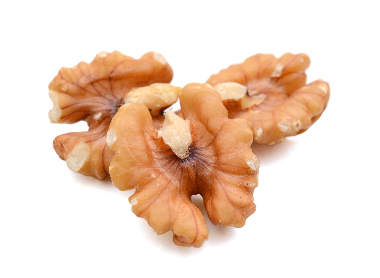 Walnusskerne, braun, auf weißem Hintergrund. Mehrere Hälften und Stücke.