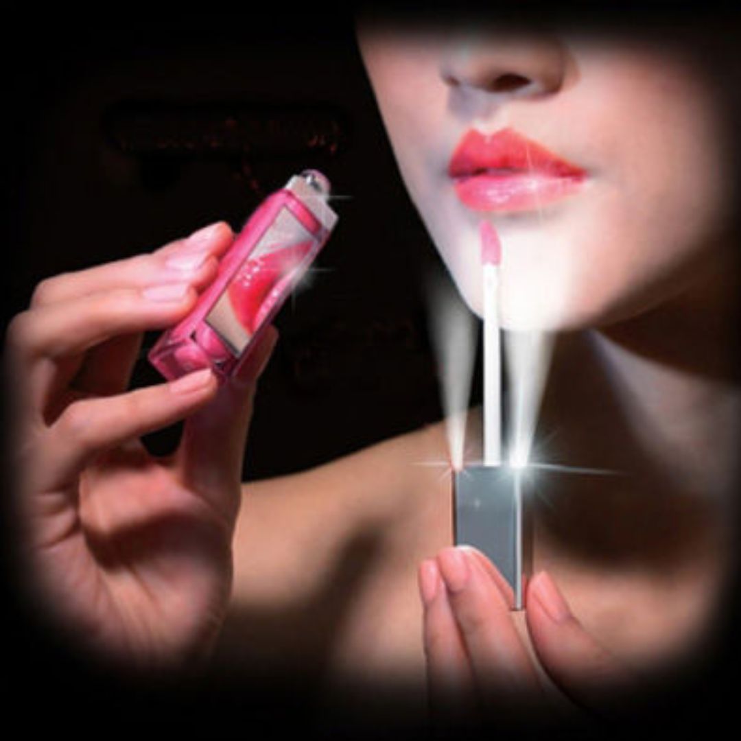 Person trägt Lipgloss auf. Lipgloss-Verpackung in der Hand. Lichteffekt.