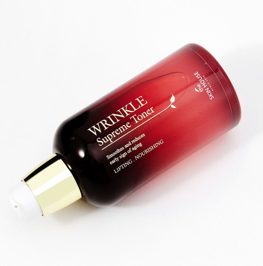 Rote Flasche mit Aufschrift WRINKLE Supreme Toner. Enthält Text: LIFTING. NOURISHING. Mit Spenderkopf und goldfarbenem Ring.
