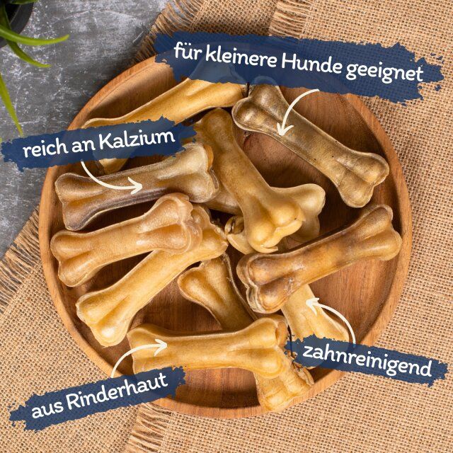 Kauknochen auf Holzschale. Beschriftung: für kleinere Hunde geeignet, reich an Kalzium, aus Rinderhaut, zahnreinigend.